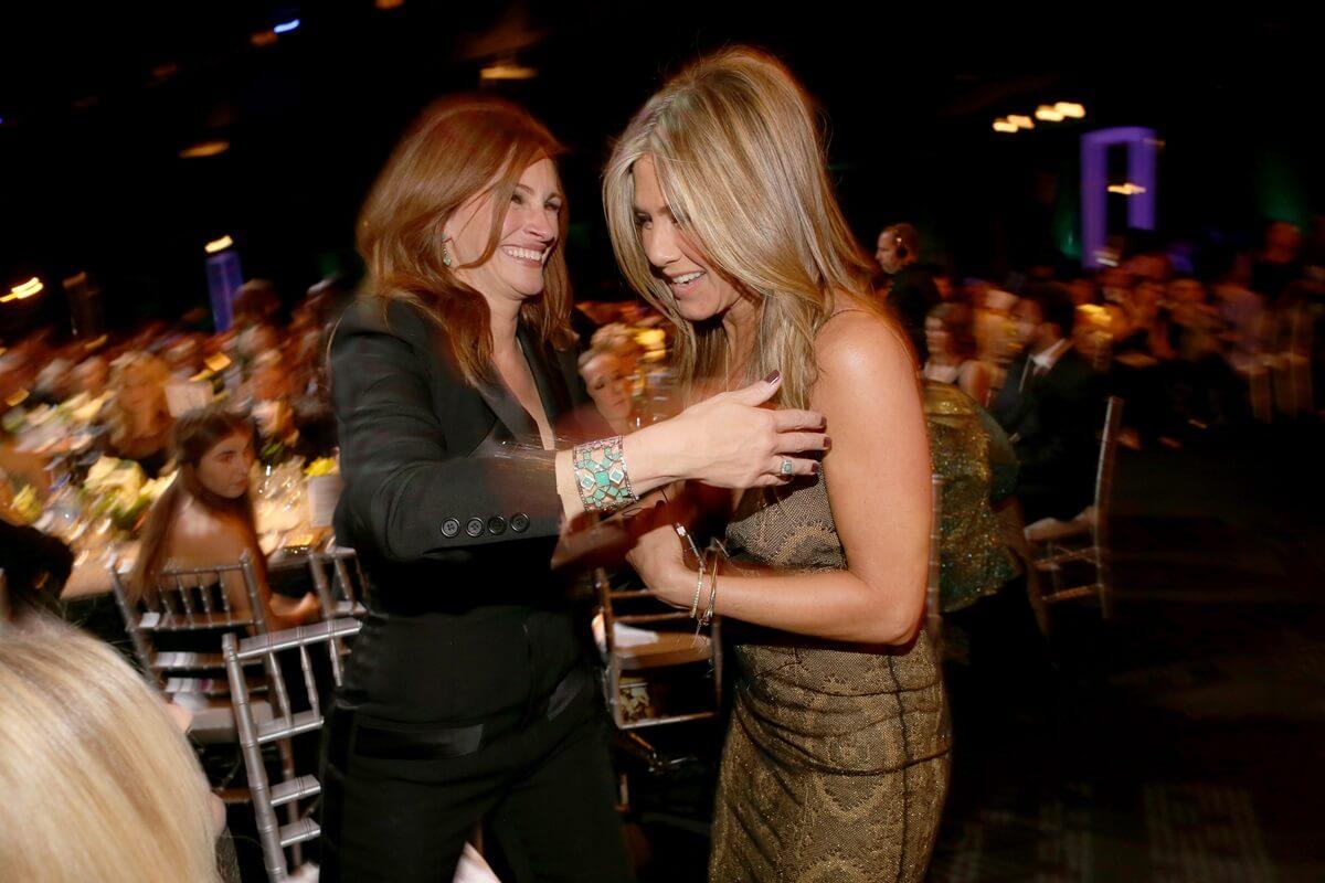 Julia Roberts and Jennifer Aniston hugging each other at TNT